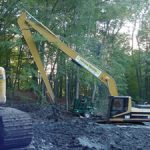 Excavator next to forest digging