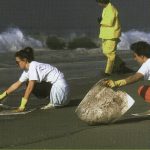3 people cleaning up beach